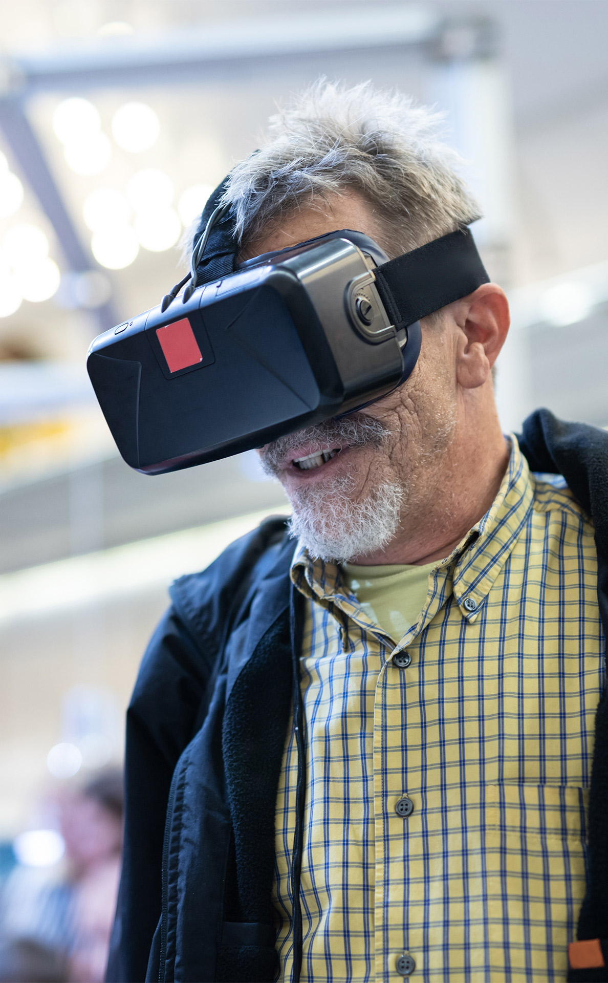 Casual senior bearded man wearing virtual reality goggles.